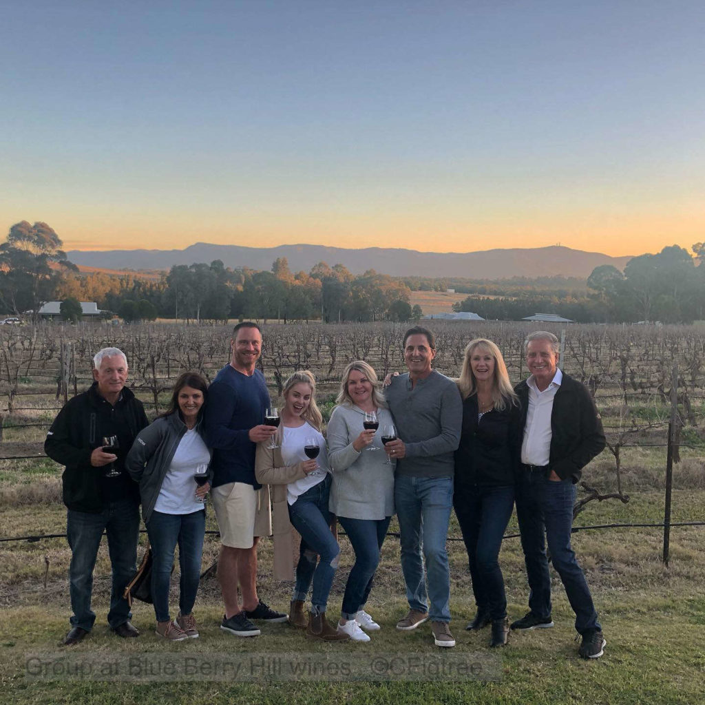 A Group at Blue Berry Hill wines at unset with vineyard in the background